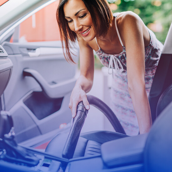 Woman vacuuming the interior of her car at Falcon Carwash